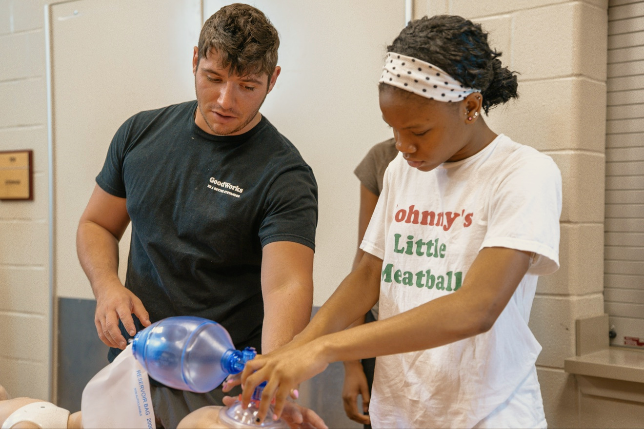 An attendee practices resuscitation with a GoodWorks volunteer at First Aid Palooza