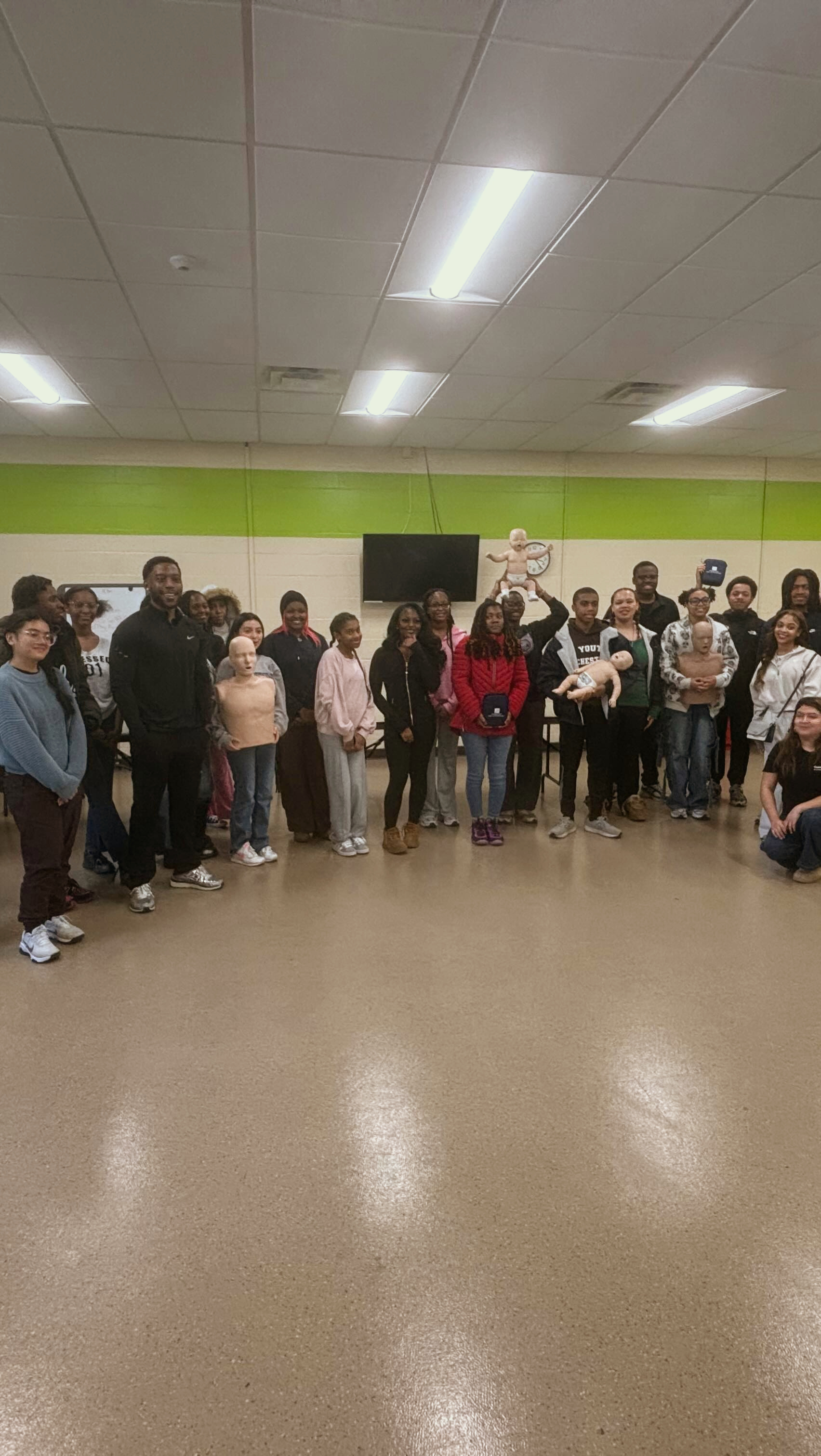 Community members gather with CPR manikins after a GoodWorks training