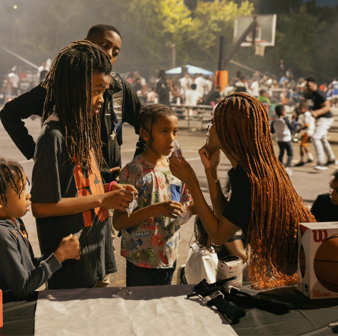 Young GoodWorks volunteers share safety resources with children at a community booth